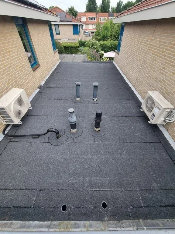 Plat dak met nieuwe bitumen dakbedekking en ontluchtingen