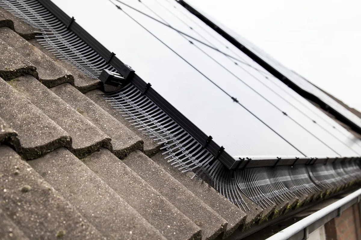 Dakpannen naast nieuw gelegde zonnepanelen